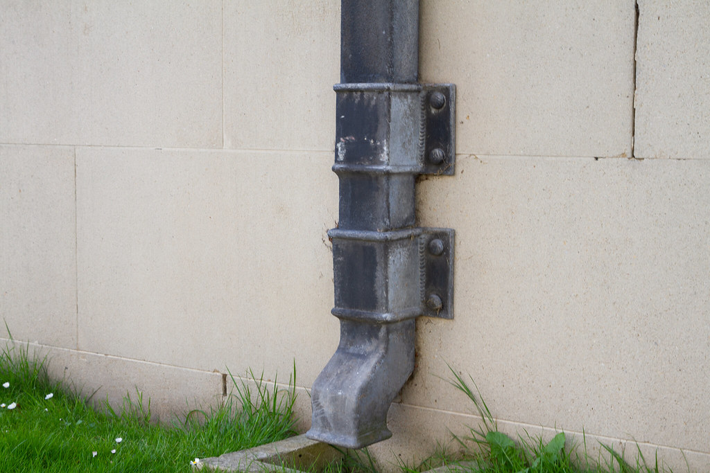 A modern downpipe fitted to an exterior wall