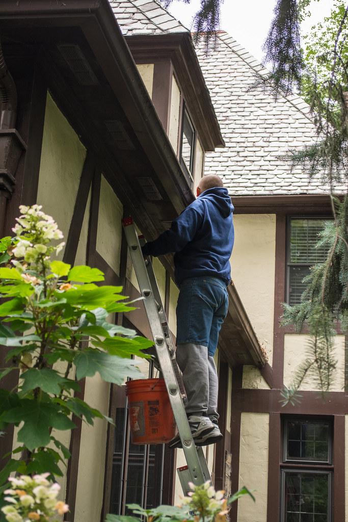Gutter cleaning from a ladder on a pitched roof