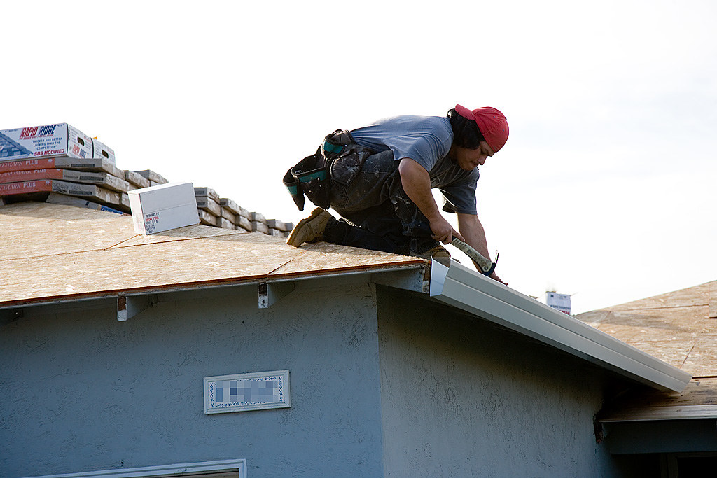 Roofer installing new roof sheeting and guttering
