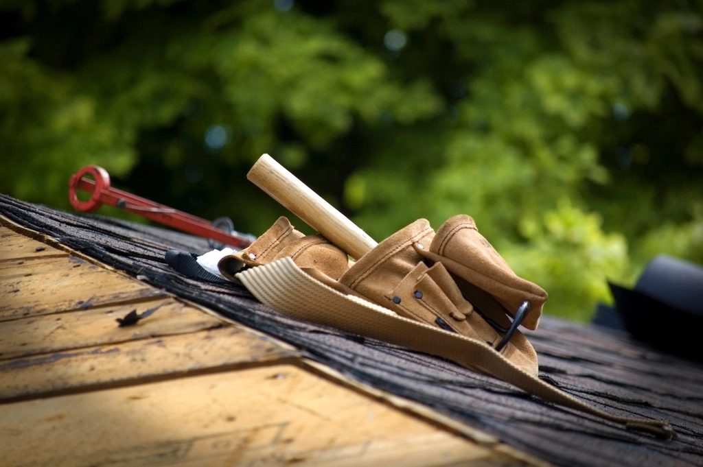A roofer's tool belt on a shingle roof
